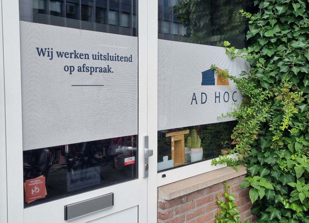 Bord met bedrijfsnaam "ad hoc" en daarnaast "wij werken alleen op afspraak"