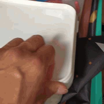 My hand opening an ice-cream tub full of glitter