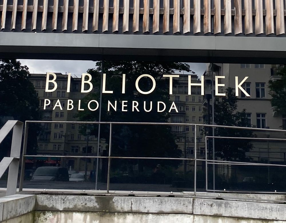 A building with the sign “Bibliothek Pablo Neruda”