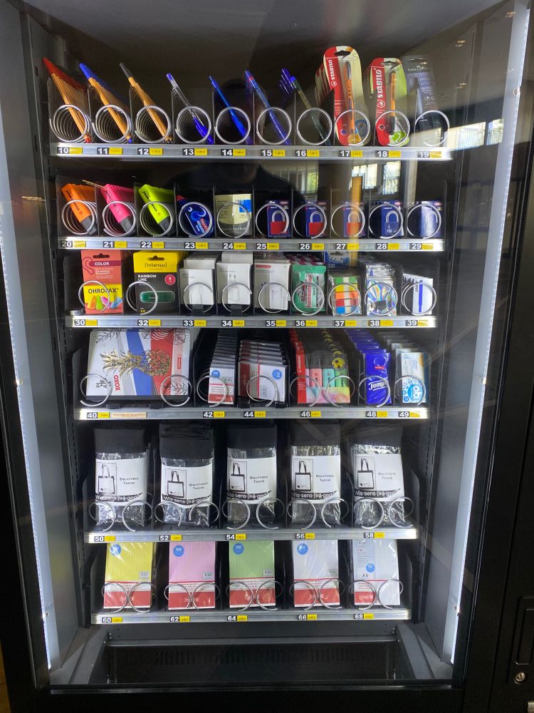 A vending machine stocked with pens, paper pads, library bags, and other practical material for writing at the library.