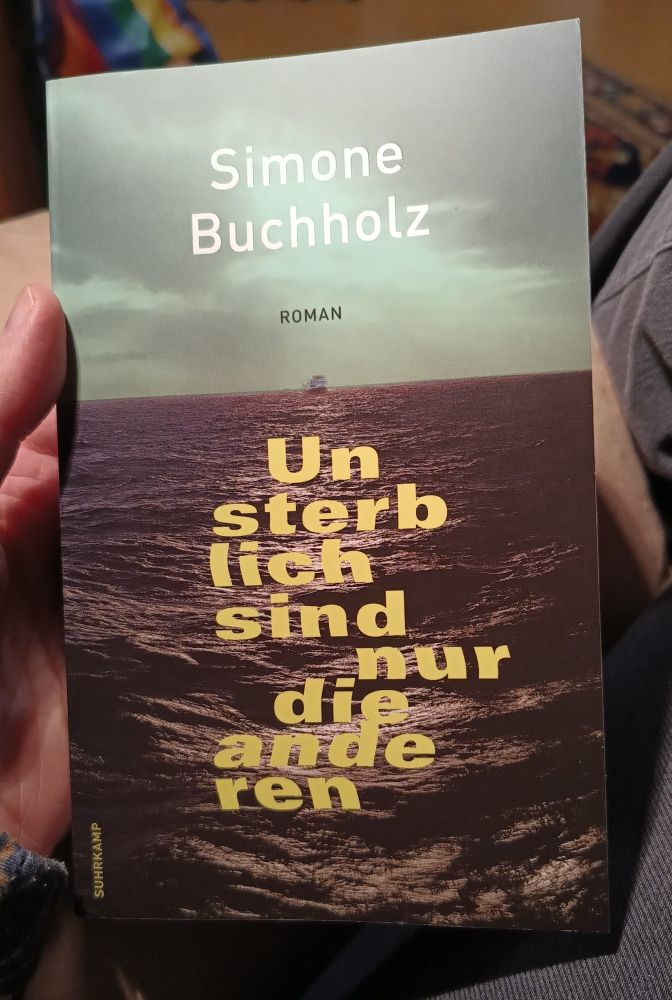 Roxane hält das Buch "Unsterblich sind nur die anderen" von Simone Buchholz in der Hand.