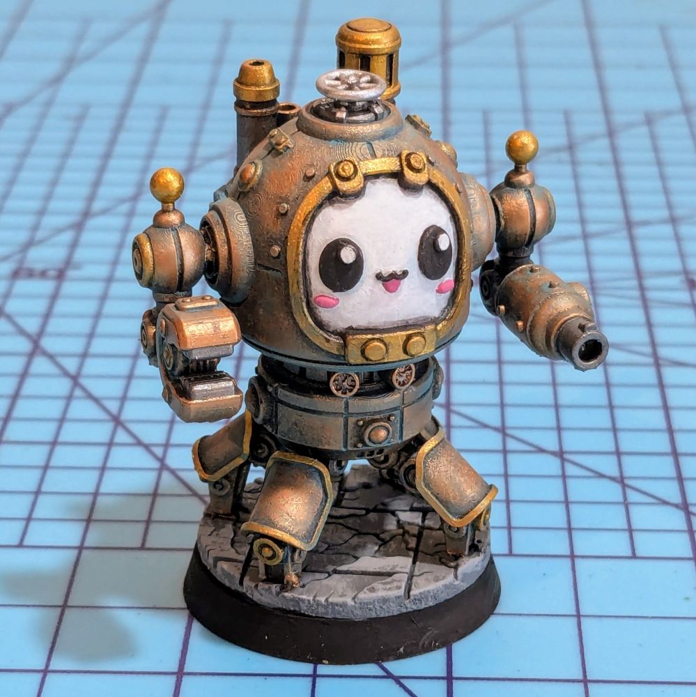 A steampunk mech miniature painted to look like oxidized copper. The mech is smiling and has crab legs