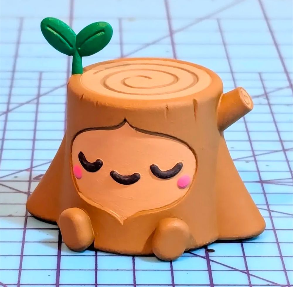 A small tree stump creature with a sleeping expression and a small sprout drowning out of the top 