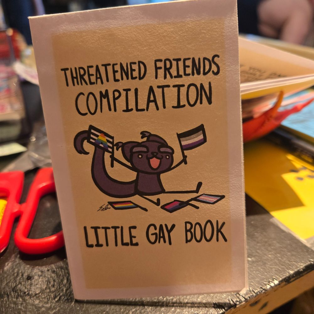 Threatened friends compilation little gay book. with a purple cat holding an ace flag and a pride flag.
