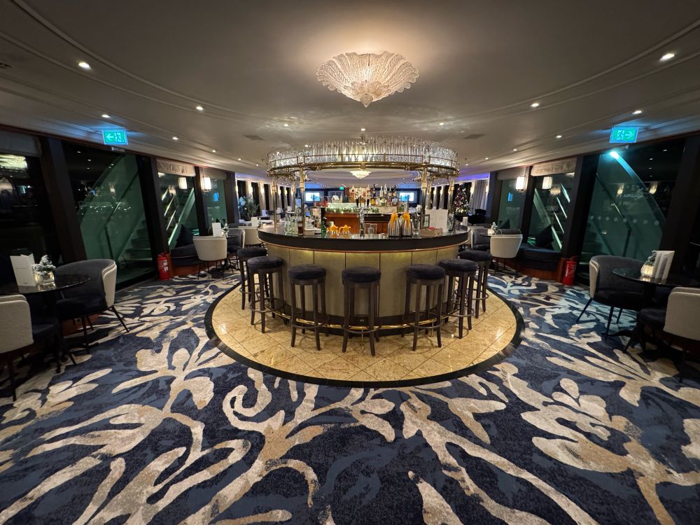 The lounge area showing a semi circular bar with stalls and tables and chairs around