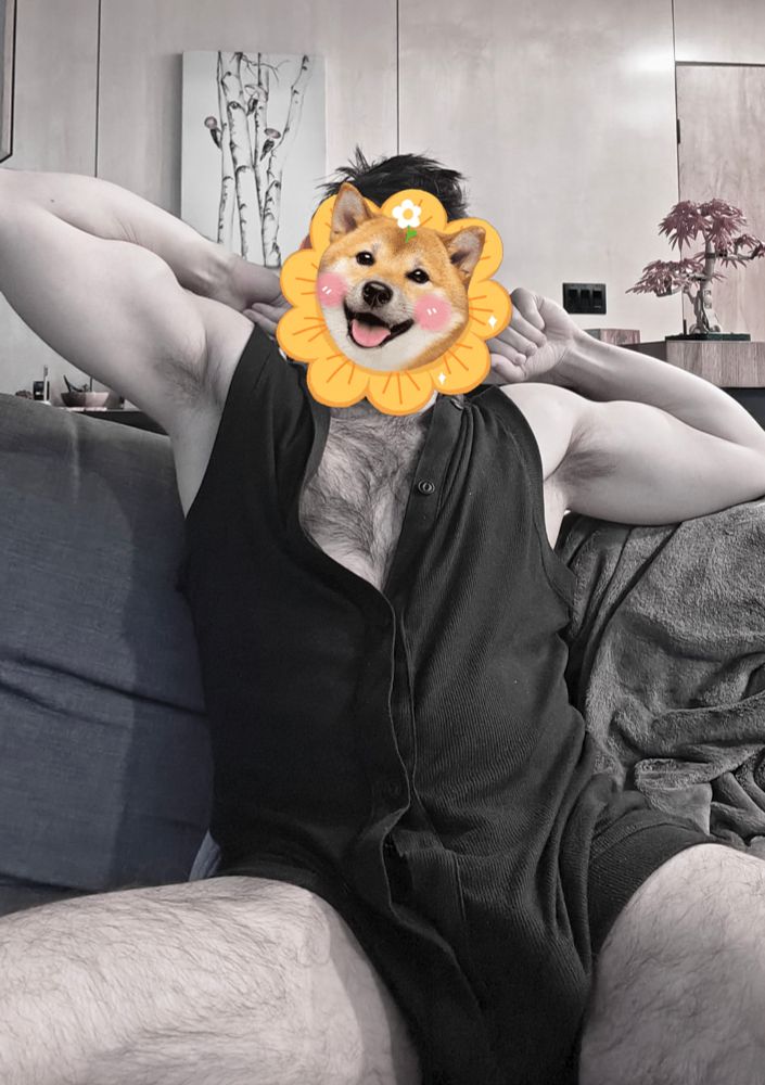 stretching out on the couch in a black sleeveless onesie, thighs and arms on display, in muted tones