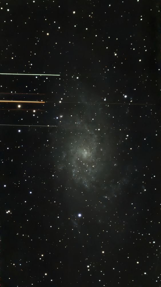 Photography of Triangulum galaxy overlaid with bright stripes from crossing satellites
