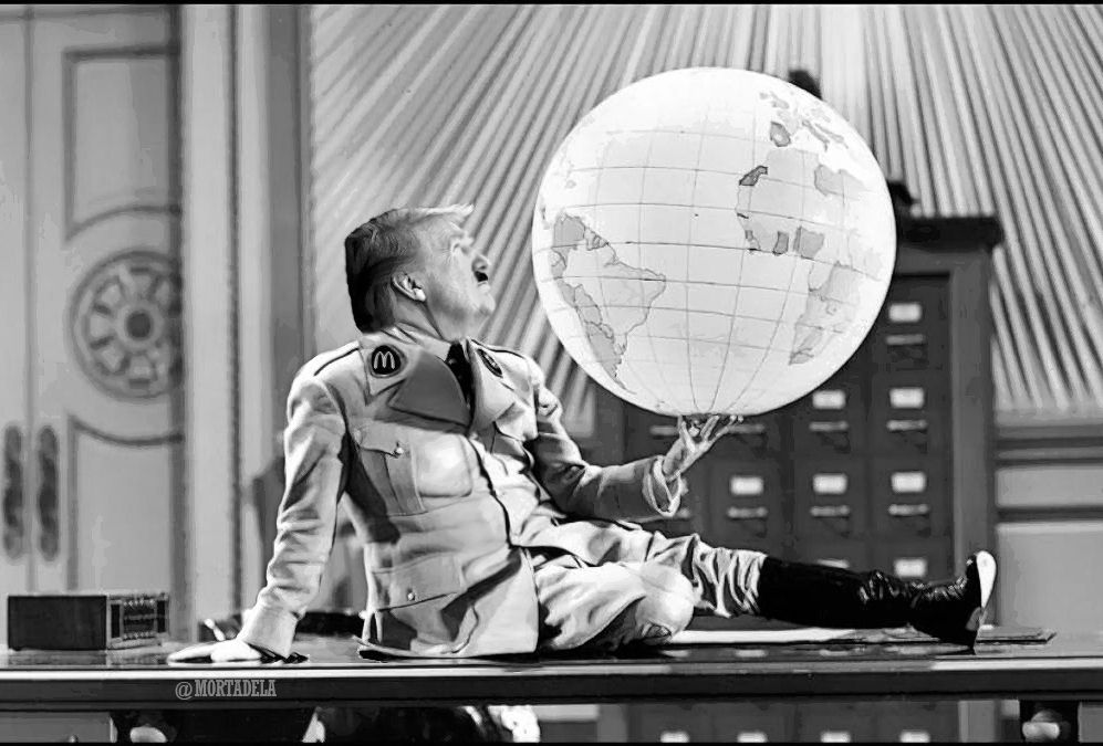 Fotograma de la película l gran dictador donde Chaplin baila con la bola de mundo editada con la cara de Tump.