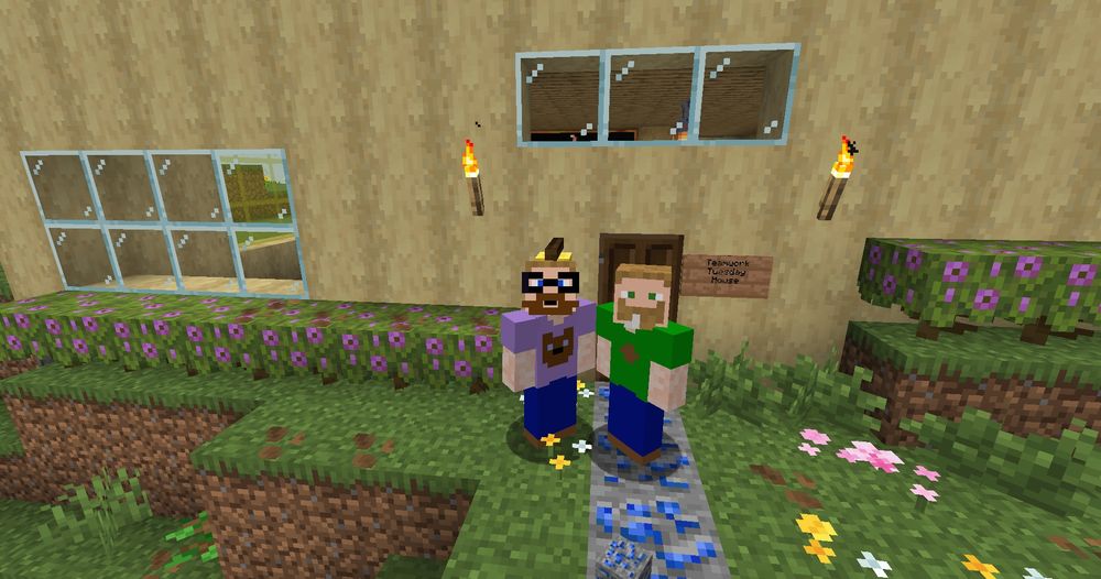 A screenshot of Andy and Bookslap's in-game personas in Minecraft standing in front of the house they created