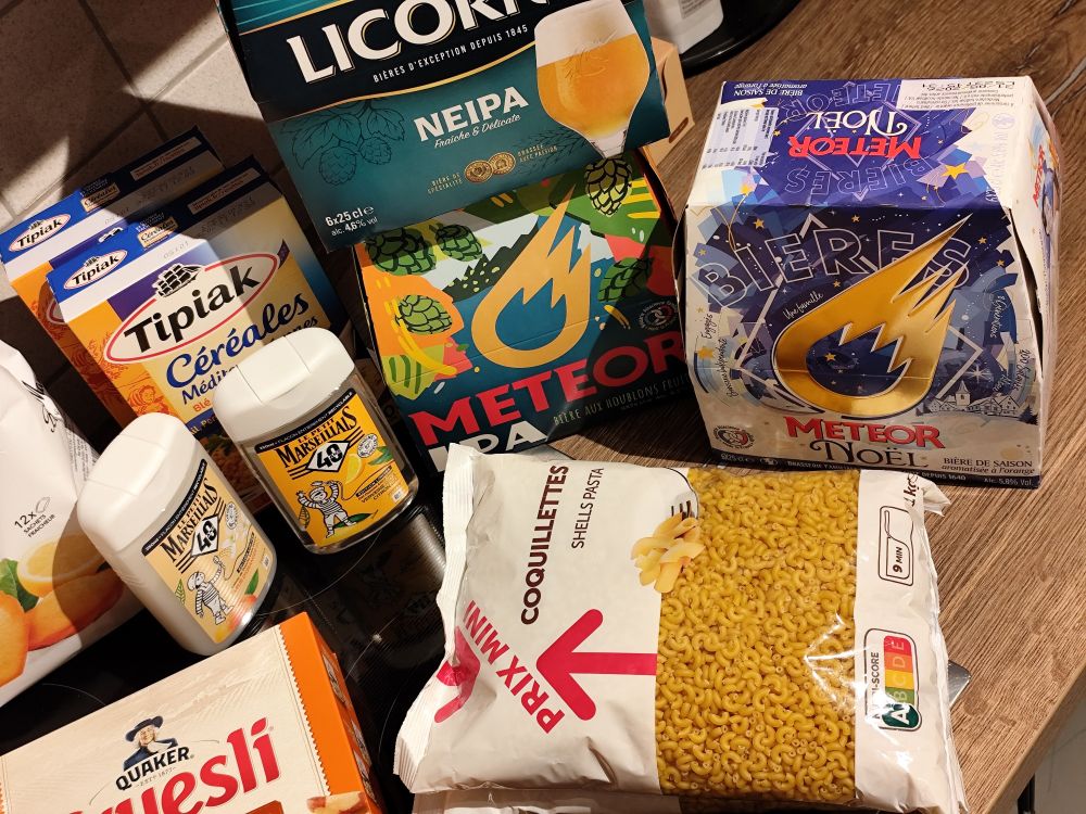 Französische Produkte aus dem Supermarkt: Hülsenfrüchte Fertigmischung, kleine Nudeln in Tüte "Coquillettes", 2 Duschgels Petit Marseillais, 3x 6erPack Bier "Noël", "NEIPA", "IPA", der günstigen Marken Meteor und Licorne.