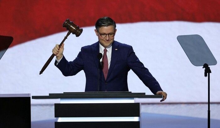 A photo of Mike Johnson holding a large gavel.
