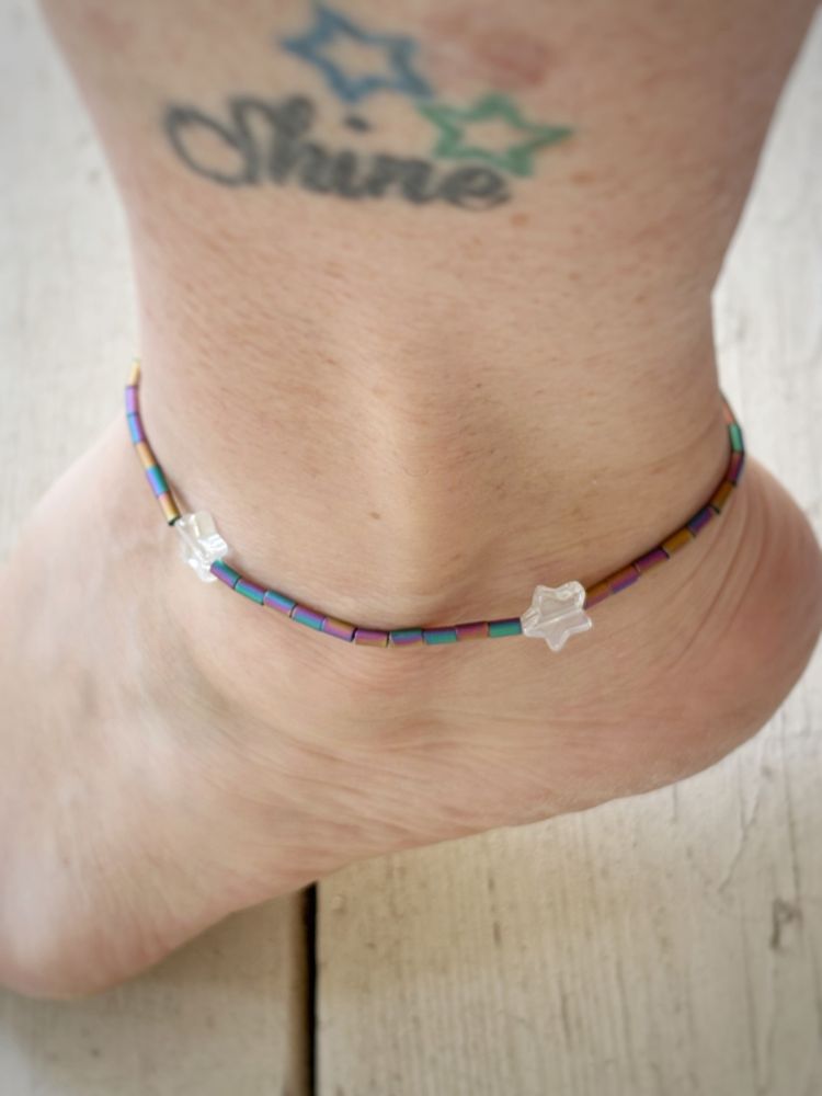 Dani’s ankle sporting an anklet made with rainbow bugle beads and glass stars