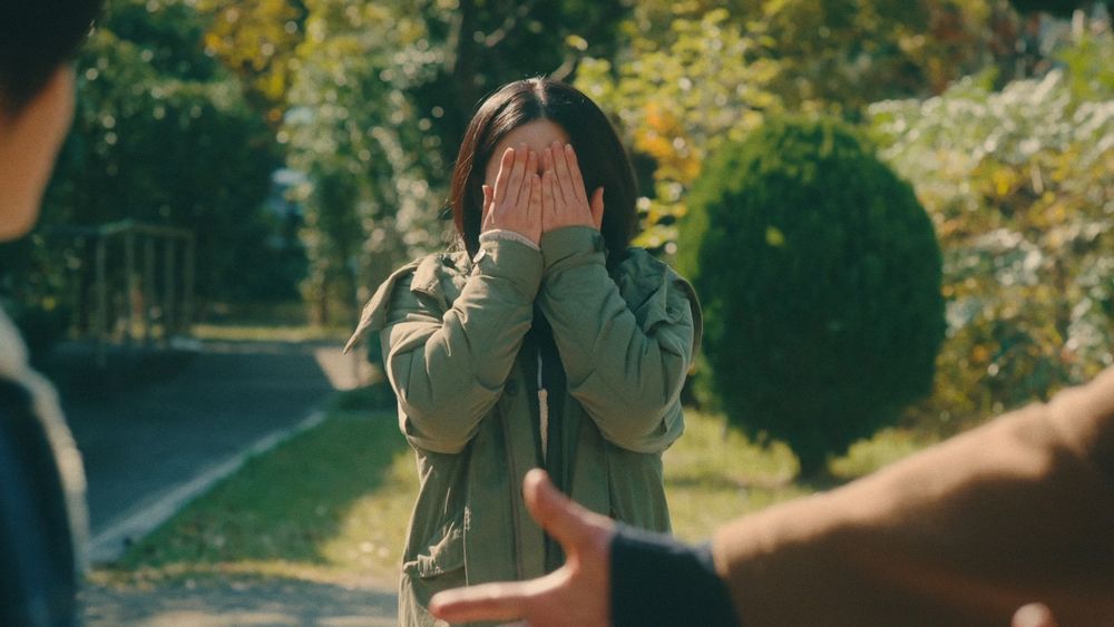 A shot of a teenage girl covering her eyes. It is a screenshot from jdrama Chosen Home.