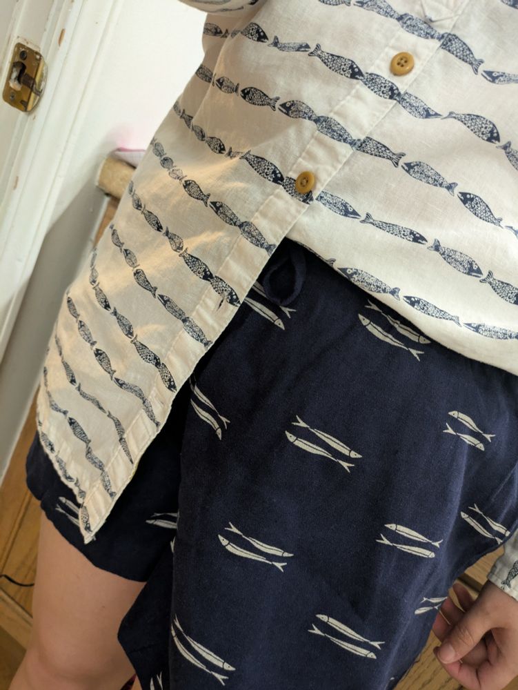 White shirt with blue sardines, tucked into blue shorts with white sardines 