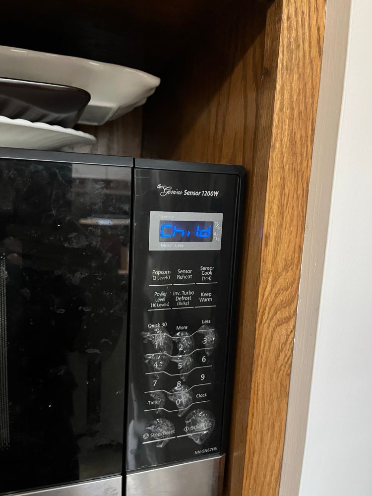 A photo of the control panel of a microwave. The digital screen says “child.” 