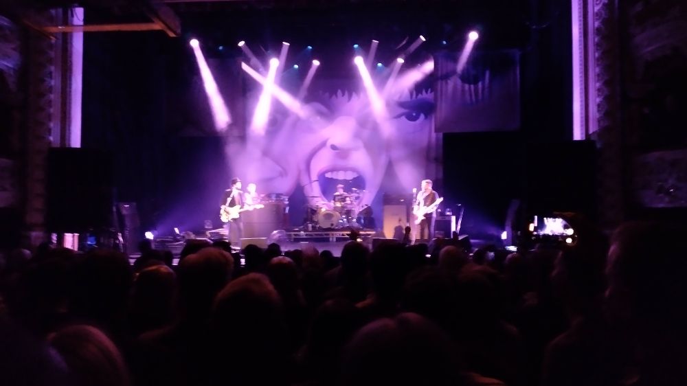 Dublin Olympia Supergrass gig - the lads on stage with loads of spotlights and a giant mouth backdrop