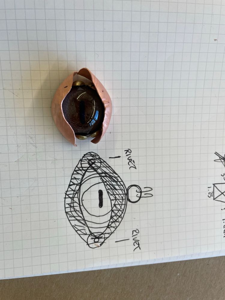 Rough sketch of jewelry is drawn next to the first rough pieces of metal I’m working with 