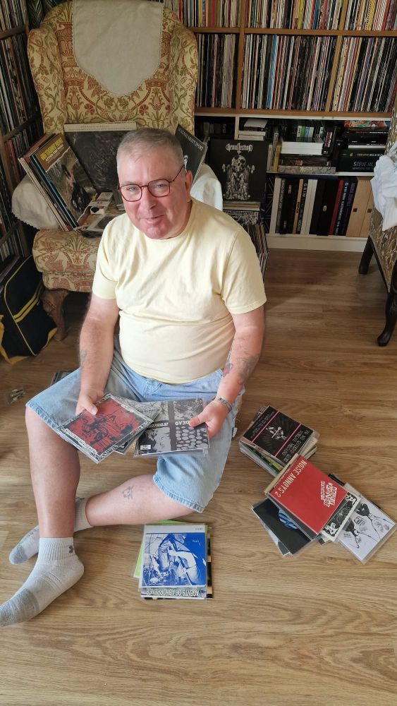 A glamorous record collector poses with a bundle of 7" records.