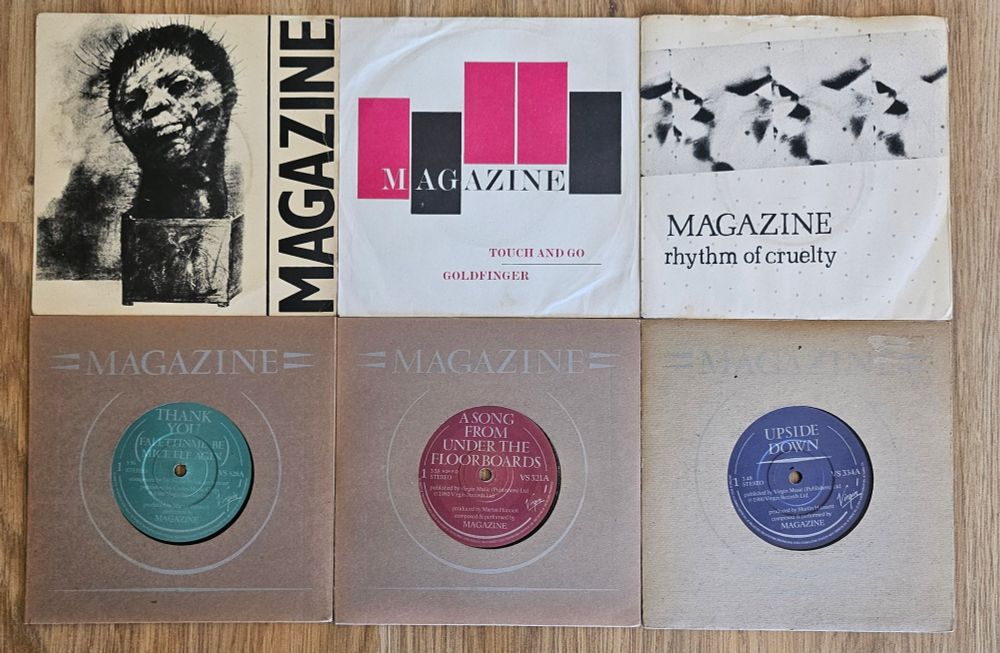 6 singles by top post-punk band MAGAZINE. 3 are picture sleeves, the other 3 are heavy cardboard with the band name embossed on both sides
Top Row: 
"Give Me Everything" b/w "I Love You You Big Dummy"
"Touch And Go" b/w "Goldfinger"
"Rhythm Of Cruelty" b/w "T.V. Baby"
Bottom Row: 
"Thank You (Falettingme Be Mice Elf Again" b/w "The Book"
"A Song From Under The Floorboards" b/w "Twenty Years Ago"
"Upside Down" b/w "The Light Pours Out Of Me"
