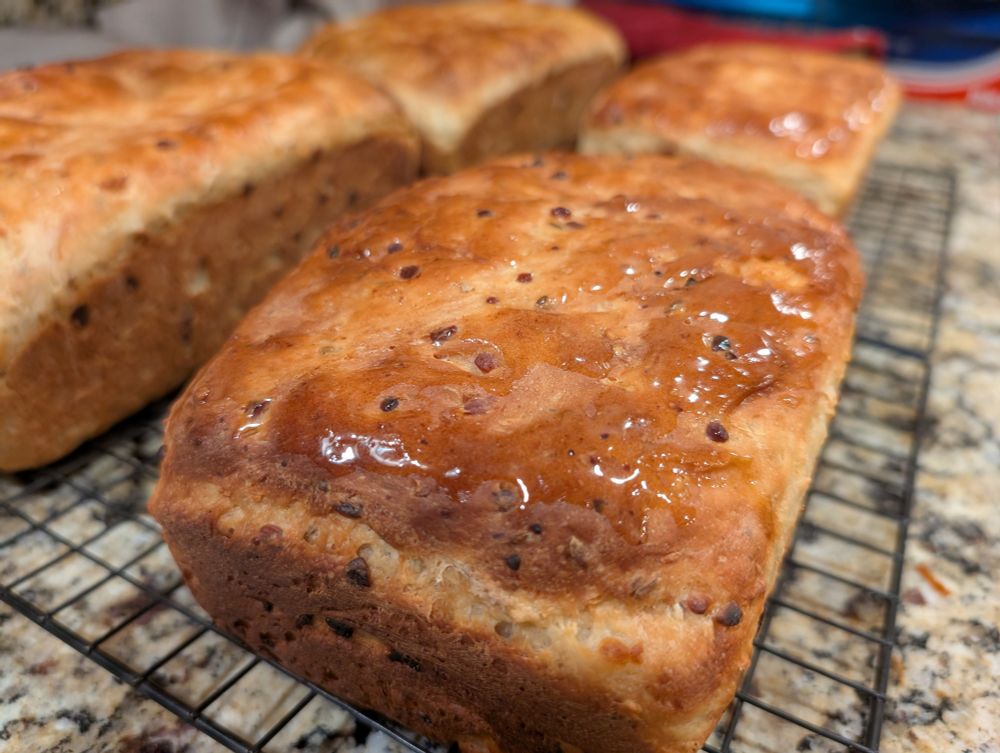 Close-up of finished loaves of bread on a cooling rack.
It glistens with spikes of butter