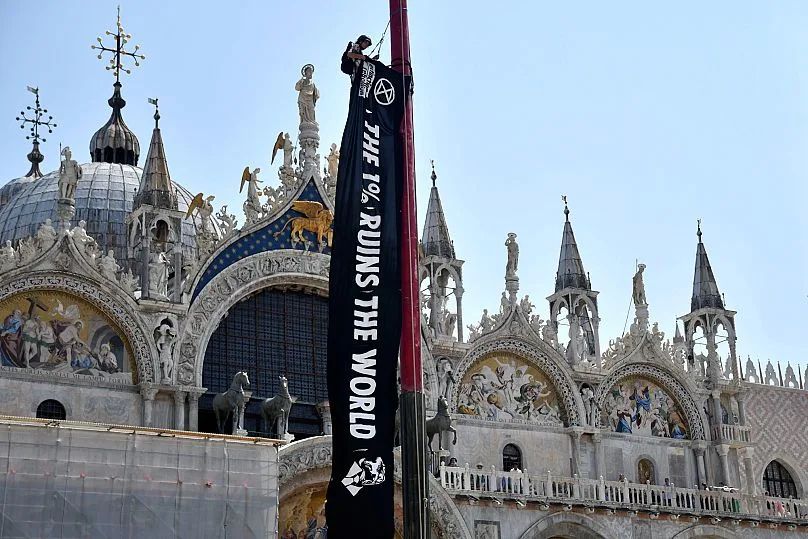 Venice with banner reading, THE 1% RUINS THE WORLD
(AP Photo)