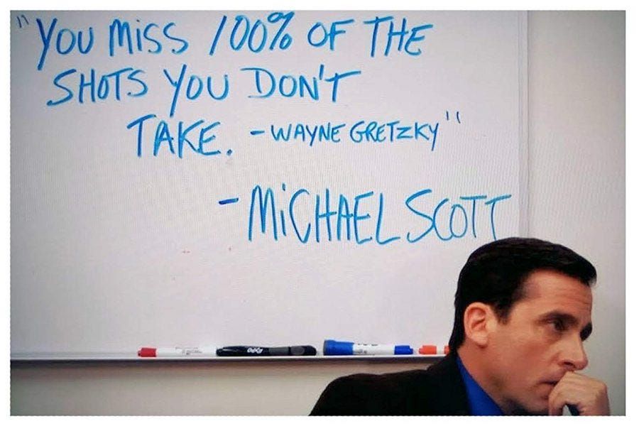 Still from the TV show "The Office", a thoughtful man sits right below a white board where the words ""You miss 100% of the shots you don't take. - Wayne Gretzky." - Michael Scott" are written.