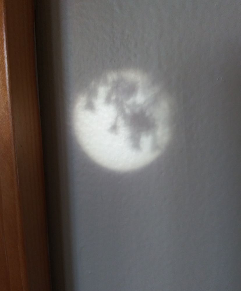 Small circle of light with a shadow on a wall