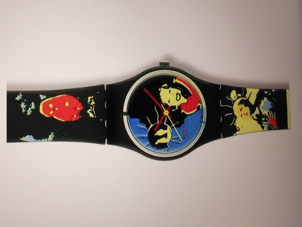 Photo of a wristwatch showing the face and part of the band, all of which are printed with heavily posterized weird and wonderful images in bright yellow, red and blue on a black background. The watch face is printed with the face of a smiling lady with black hair who may be on the phone, as well as a circle beside her head with possibly the silhouettes of two human figures inside and squiggly lines radiating outward. It's bold, bright, doesn't make sense and a beautiful woman is smiling at me. I love it.