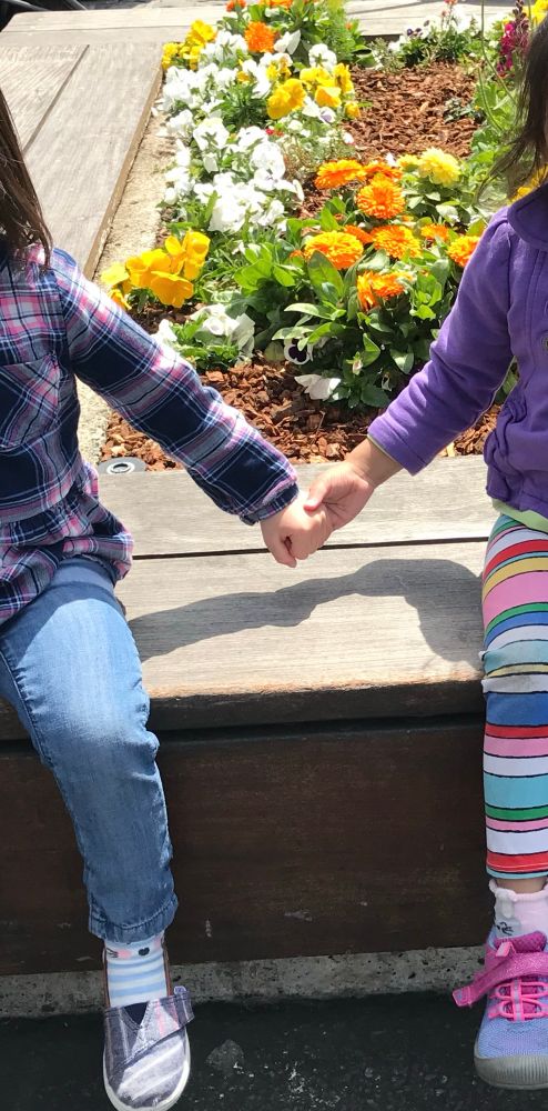 The Innocent Love of Friendship, the warmth of your hand in mine. Sitting on a sunny day, a quiet shared moment between two friends, spring marigolds and pansies blooming in the background. 