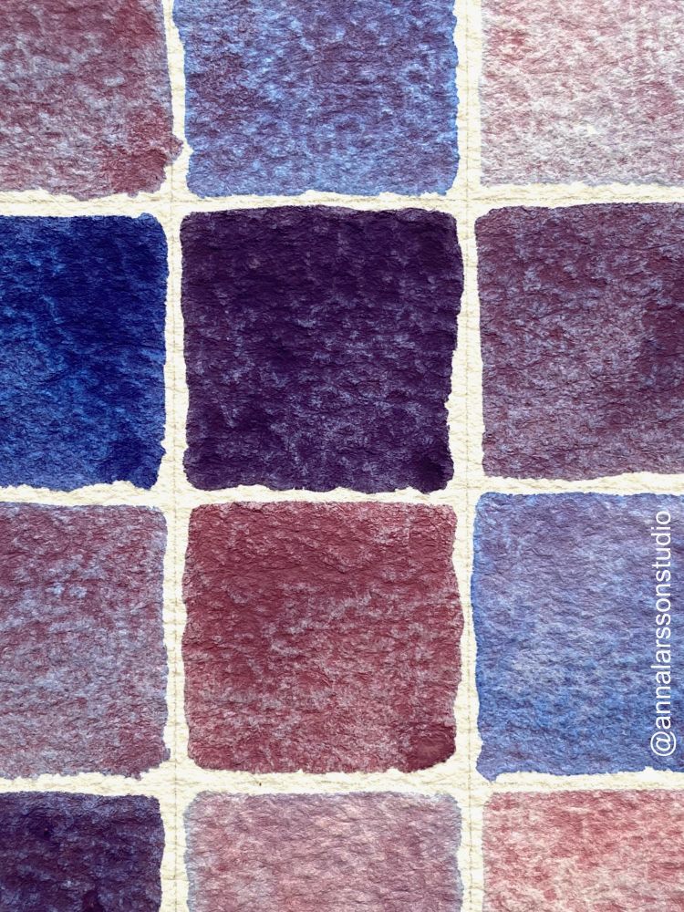 Closeup of watercolor chart with colors mixed from Cobalt Blue and Potter’s Pink. You can see a darker purple, a lighter purple, a dark blue, lighter blues, and several raspberry pinks and lavenders.