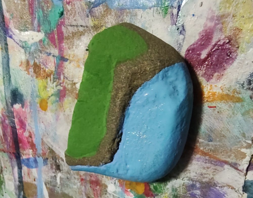 Rock painted to look like grass near water