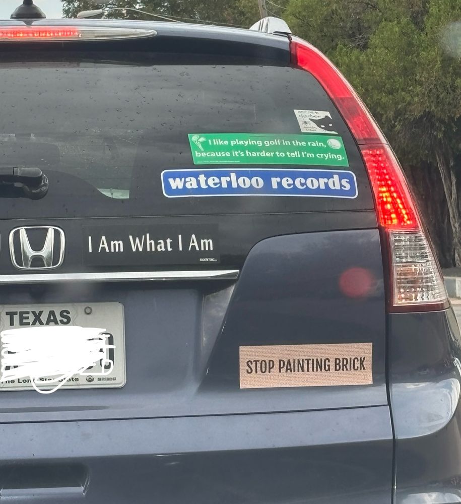 A Honda with several bumper stickers including one that says "Stop Painting Brick"