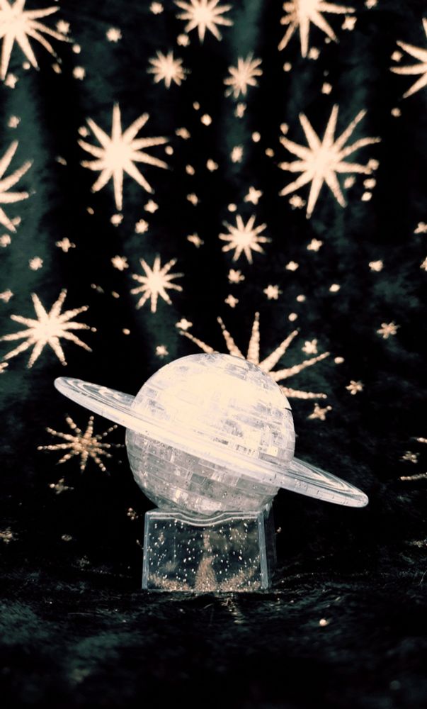 Photo of a saturn shaped object with my starry blanket in the background