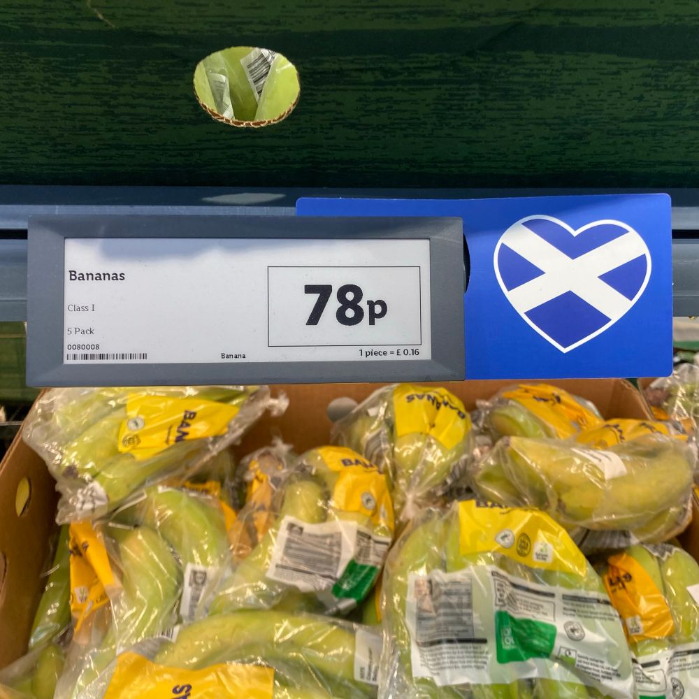 Shelf edge price label for bananas, with a Scottish flag printed alongside, implying that the bananas are of Scottish origin. 