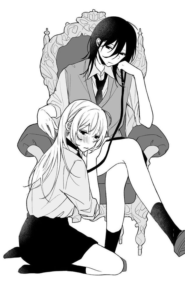 girl leashed at the foot of another woman sitting on a chair holding the leash