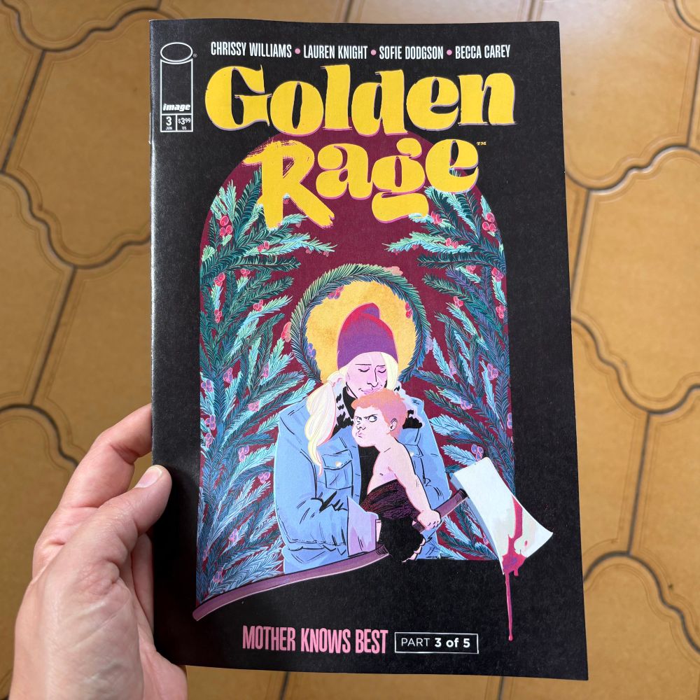 Golden Rage issue three cover showing denim clad axe wielding blonde woman with a tough baby in her arms. We put this image on a Christmas card last year. 