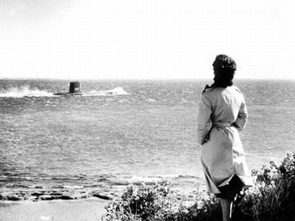 Ava Gardner standing on the beach as a submarine sails off to find other people in the uplifting comedy On the Beach.