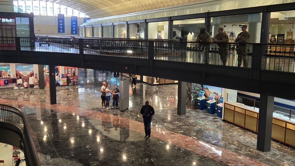 National Guardsmen in combat fatigues watching over a balcony at Washington's Union Station