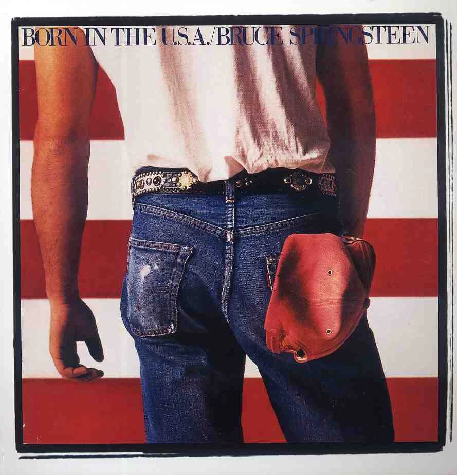 Album cover for Bruce Springsteen's Born in the USA.
It shows a man looking away from us toward a large US flag.  The man has a white t-shirt and jeans with a metal studded belt and a red working man's hat tucked into his rear pocket.