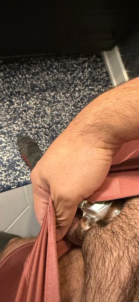 Looking down at my crotch showing a tease of a cock cage