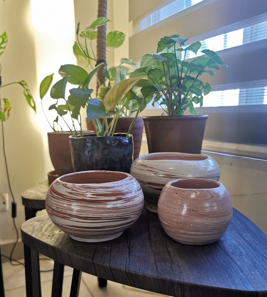 Photo of three ceramic pots made in a ceramic wheel using red and white clay half mixed to show the difference between the clay colors 