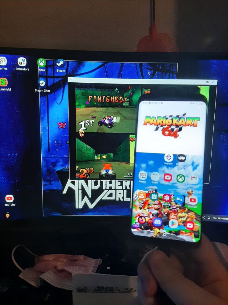 A Samsung Galaxy S8 connected via a USB dock simultaneously displaying a specialized Samsung DeX desktop running Duckstation with Crash Team Racing. Four bluetooth devices; 3 controllers and 1 mouse, connected as input devices. The phone continues to act as normal.