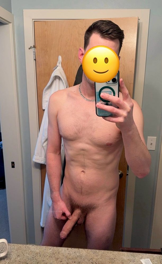 A naked mirror selfie in my bathroom with terrible lighting showing off my hard uncut penis. Face obscured with an emoji sticker. 