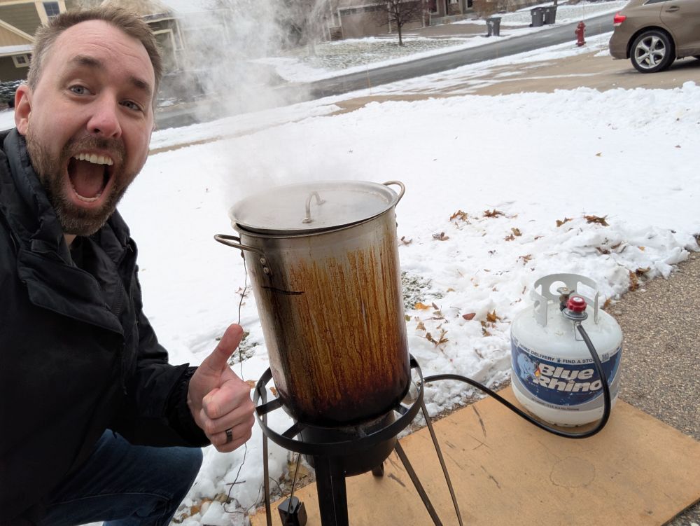 Me taking a selfie next to the tank with a turkey deep frying inside 