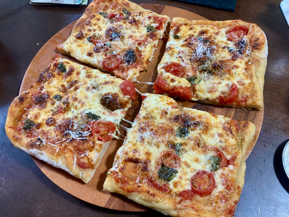 Bonci-style al taglio slices, except square. Done in a 12’’ Lloyd pan. Tomato sauce, mini tomatoes, mozzarella, basil, parm