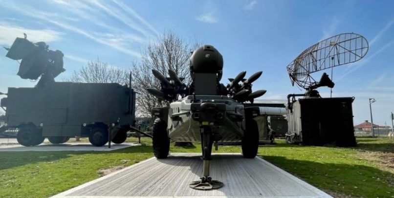 photo, colour, type 86 radar, rapier missile system and type 95 radar at the RAF Air Defence Radar Museum. The three systems are all dark green in colour and places on concrete squares surrounded by grass, under a blue sky.