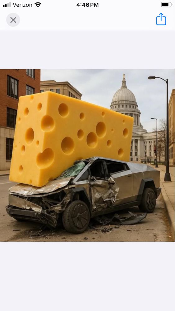 A giant cheese crushes a Tesla.