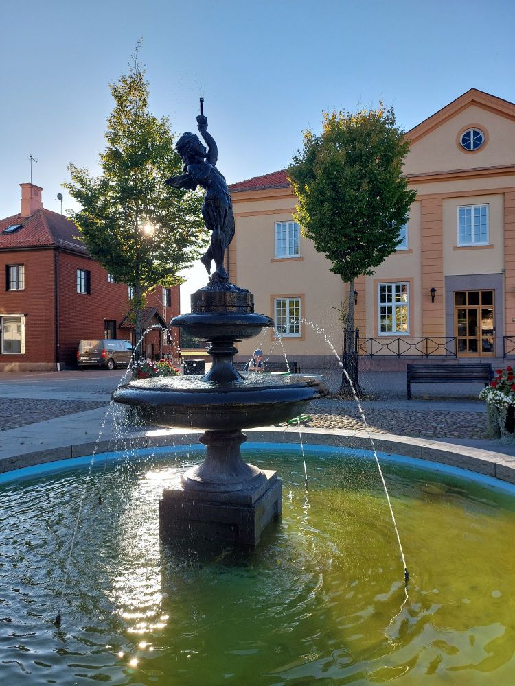 Brunnen mit Figur im Gegenlicht.