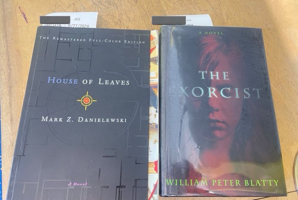 Two books sit side by side. On the left is House of Leaves by Mark C Danielewski. On the right is The Exorcist by Willam Peter Blatty. 