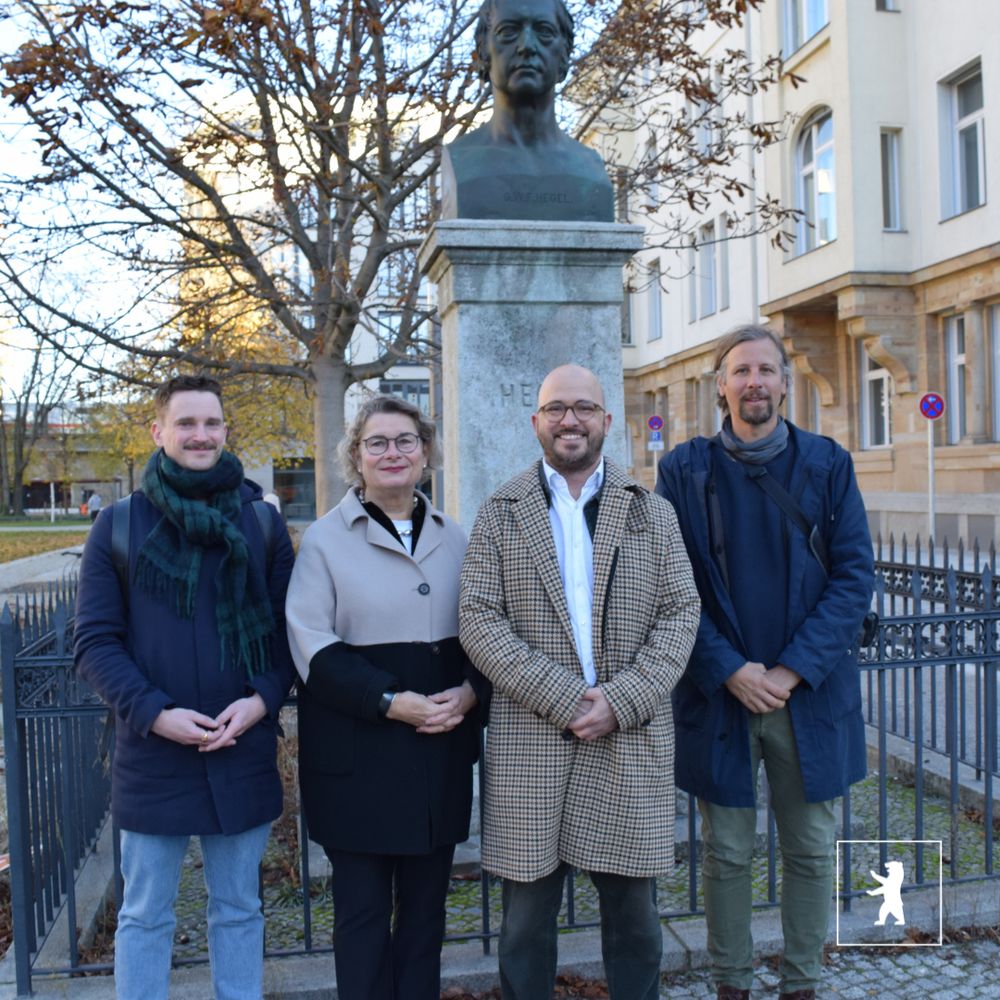Dirk Sadtler (Franz Reschke Landschaftsarchitekten), Senatsbaudirektorin Petra Kahlfeldt, Bezirksstadtrat Christopher Schriner und Jan Siewert Straßen- und Grünflächenamt Mitte stehen vor dem Hegel-Denkmal.